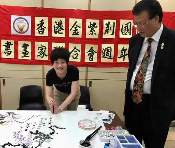 香港著名书法家梁宝琦小姐在笔上会,右为著名侨领王天为先生